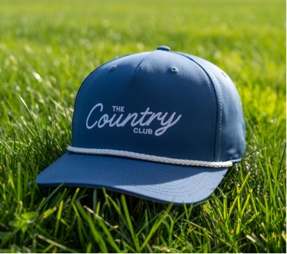 A detailed close-up of the Richardson 256 Rope Hat, showcasing its unique blend of classic and modern style. The hat features a durable cotton twill front, a breathable mesh back, an adjustable snapback closure, and a stylish rope accent along the visor.